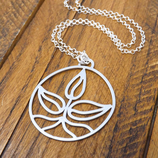 Right angle view of an argentium silver earth element necklace with a sterling silver rolo style chain.