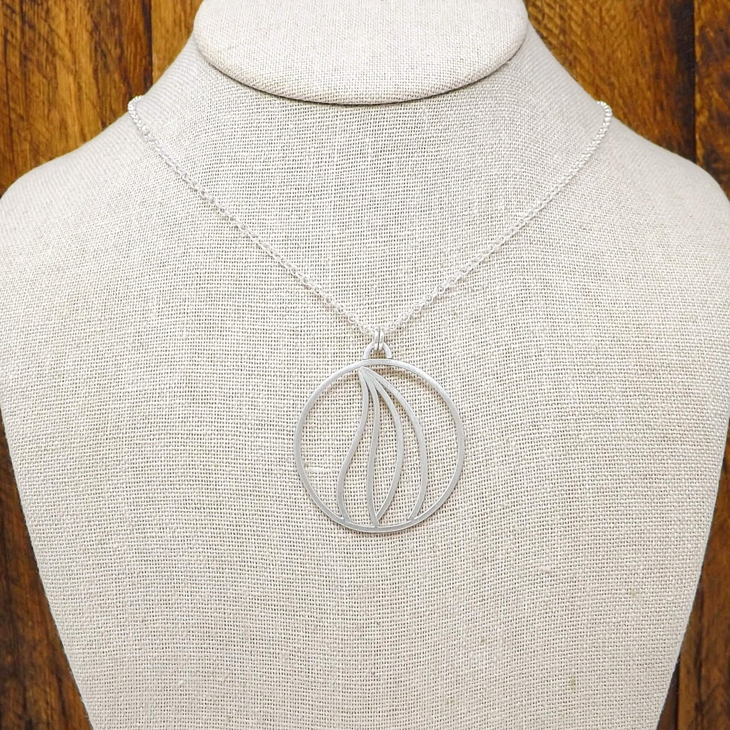 Display bust view of an argentium silver fire element necklace with a sterling silver rolo style chain.
