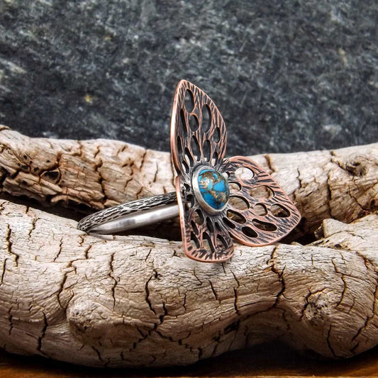 Side view of a copper and sterling silver flower ring featuring a copper turquoise gemstone.