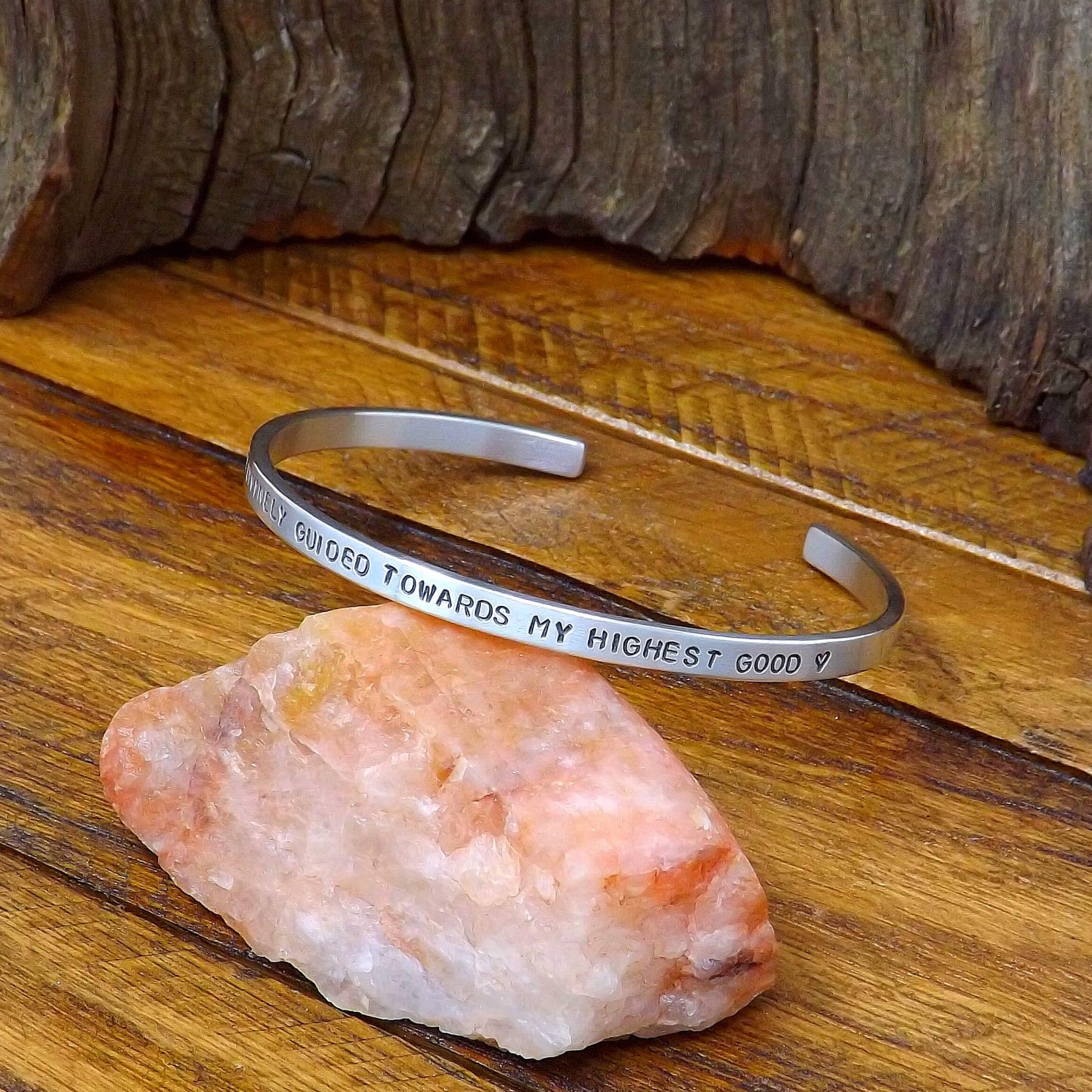 Right side view of a sterling silver affirmation cuff bracelet hand-stamped with "I Am Divinely Guided Towards My Highest Good".