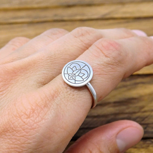 Sterling silver classic band ring with large Jenn's Zen Creations hand-stamped logo, worn on a finger.