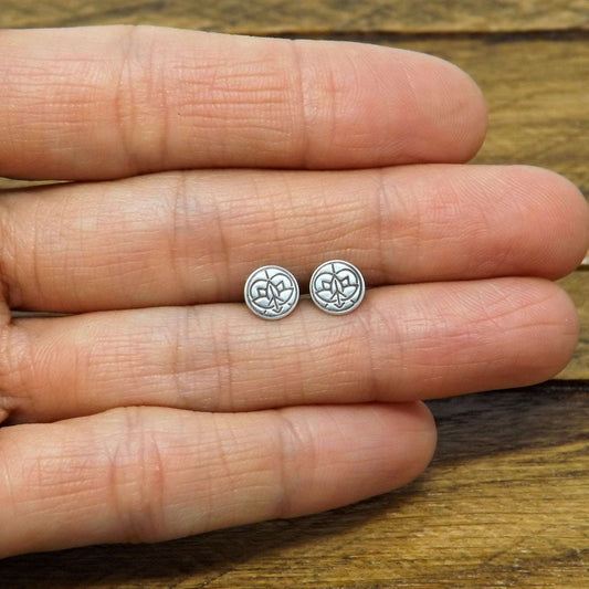 Size reference view of a pair of sterling silver stud earrings hand-stamped with small Jenn's Zen Creations logo.