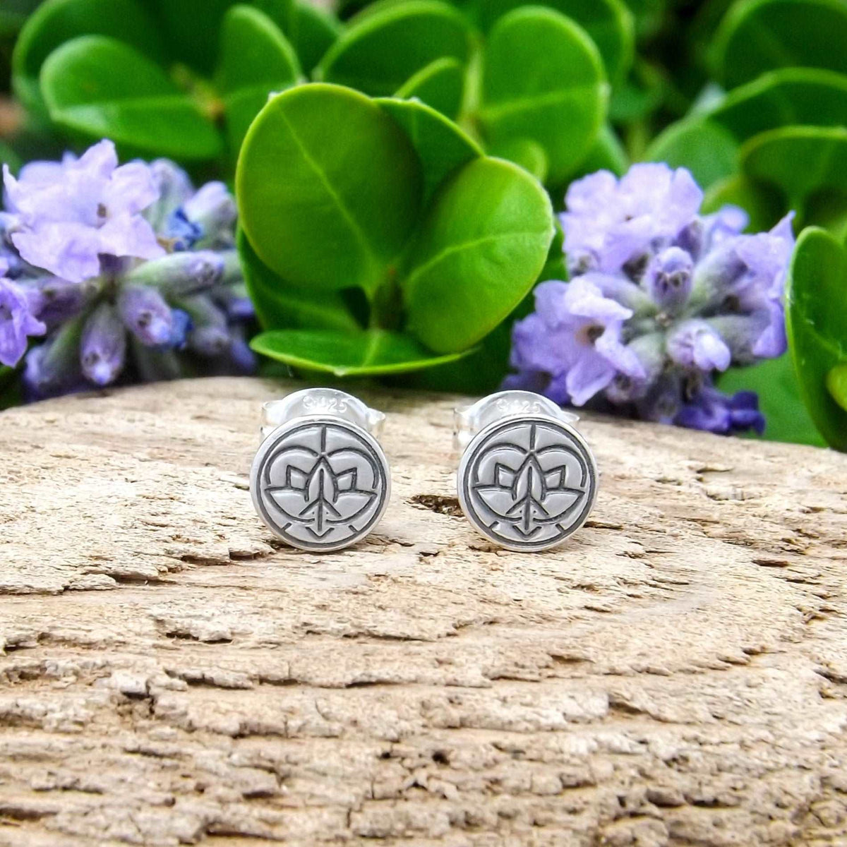 Front view of a pair of sterling silver stud earrings hand-stamped with small Jenn's Zen Creations logo.