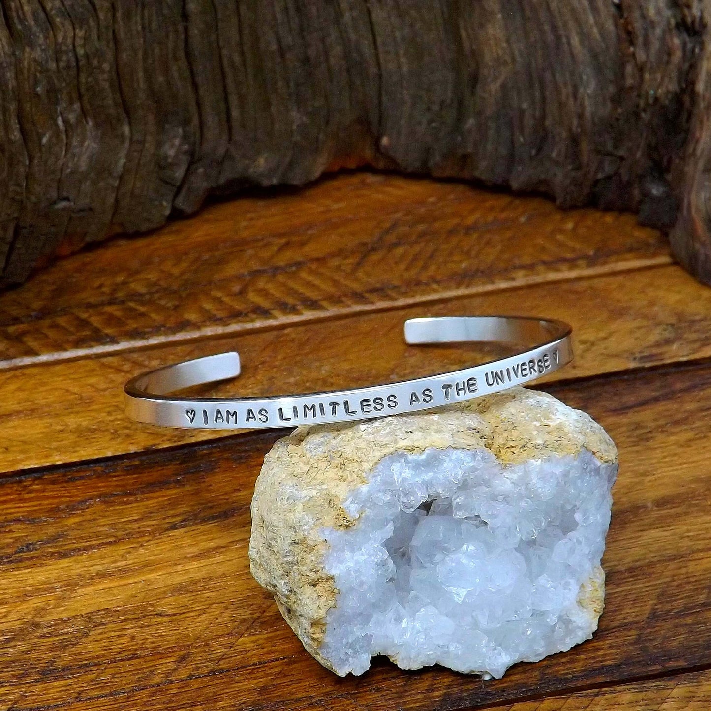 Left side view of a sterling silver affirmation cuff bracelet hand-stamped with "I AM AS LIMITLESS AS THE UNIVERSE".