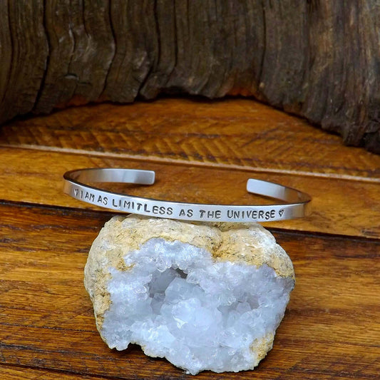 Right side view of a sterling silver affirmation cuff bracelet hand-stamped with "I AM AS LIMITLESS AS THE UNIVERSE".