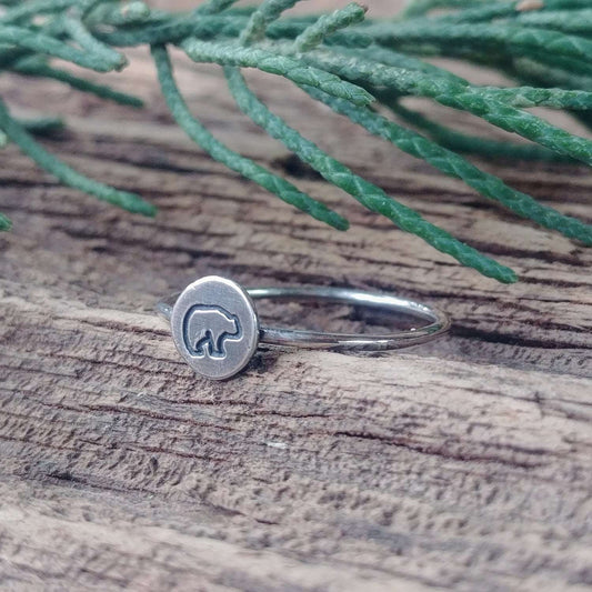 Right angle view of a sterling silver stacking ring hand-stamped with a baby bear design.