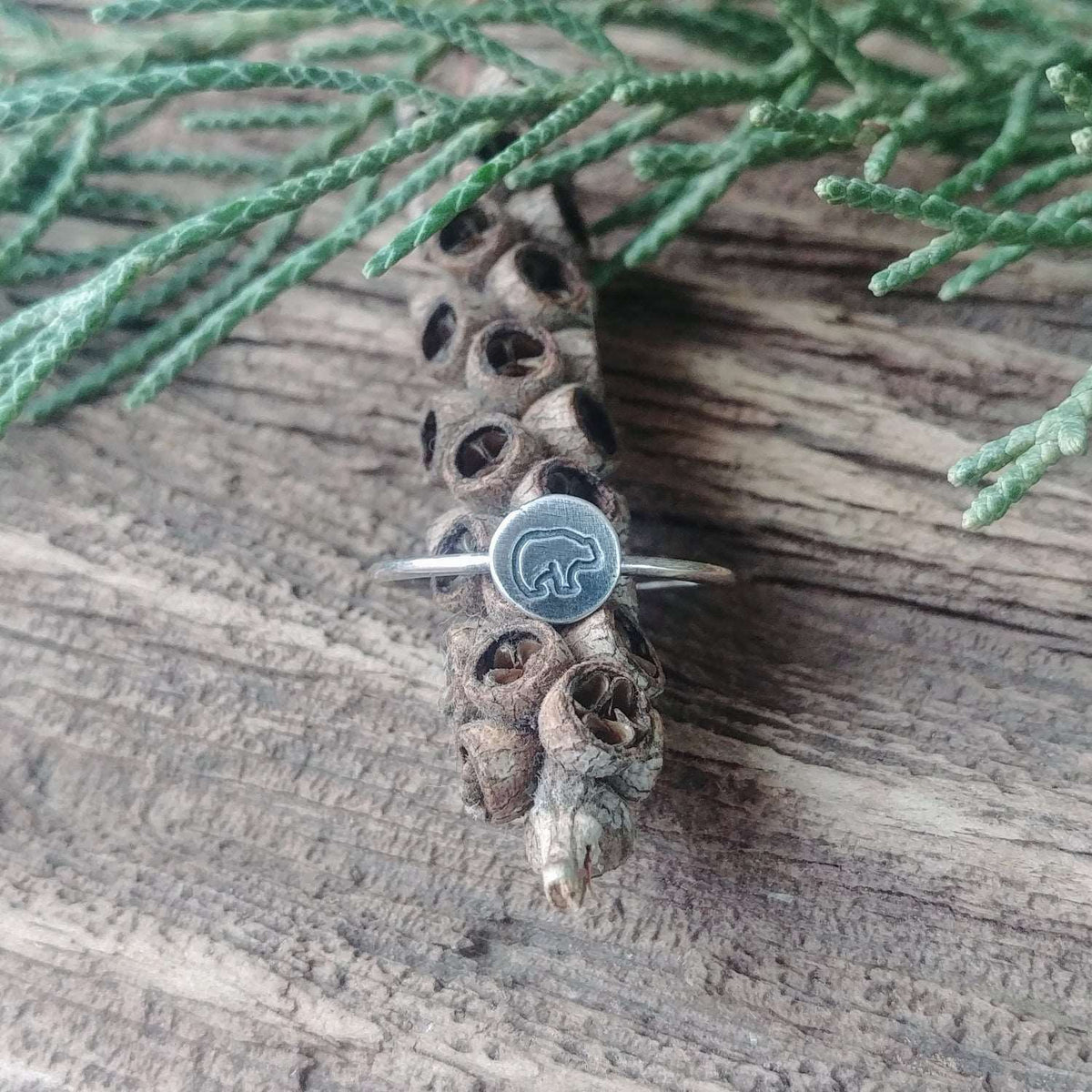 Front view of a sterling silver stacking ring hand-stamped with a baby bear design.
