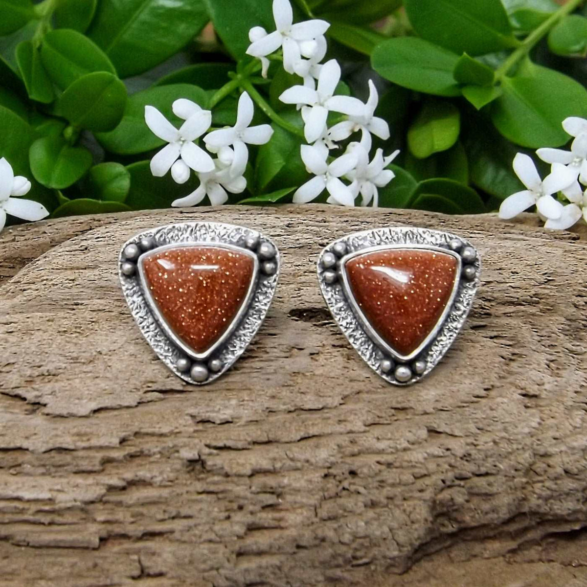 Front view of a pair of silver goldstone stud earrings.