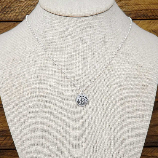 Display bust view of a sterling silver necklace hand-stamped with a starry night forest design.