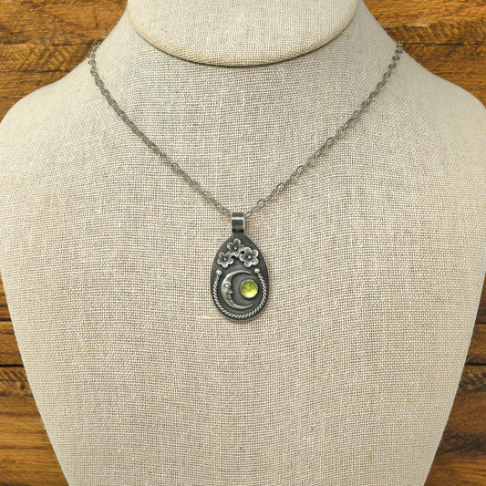 Sterling silver cherry blossom and crescent moon necklace with rose cut faceted peridot gemstone on necklace bust.