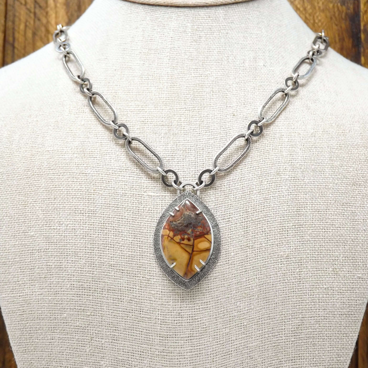 Display bust view of a sterling silver necklace with a prong set cold mountain jasper gemstones and chunky chain.