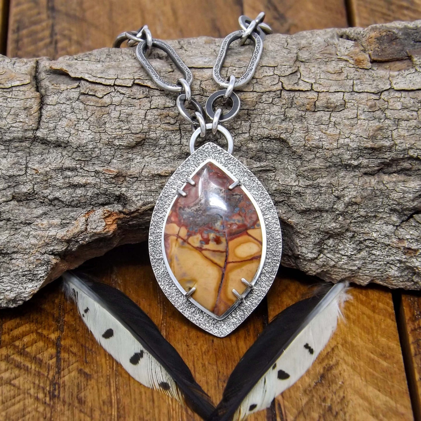 Front view of a sterling silver necklace with a prong set cold mountain jasper gemstone and chunky chain.