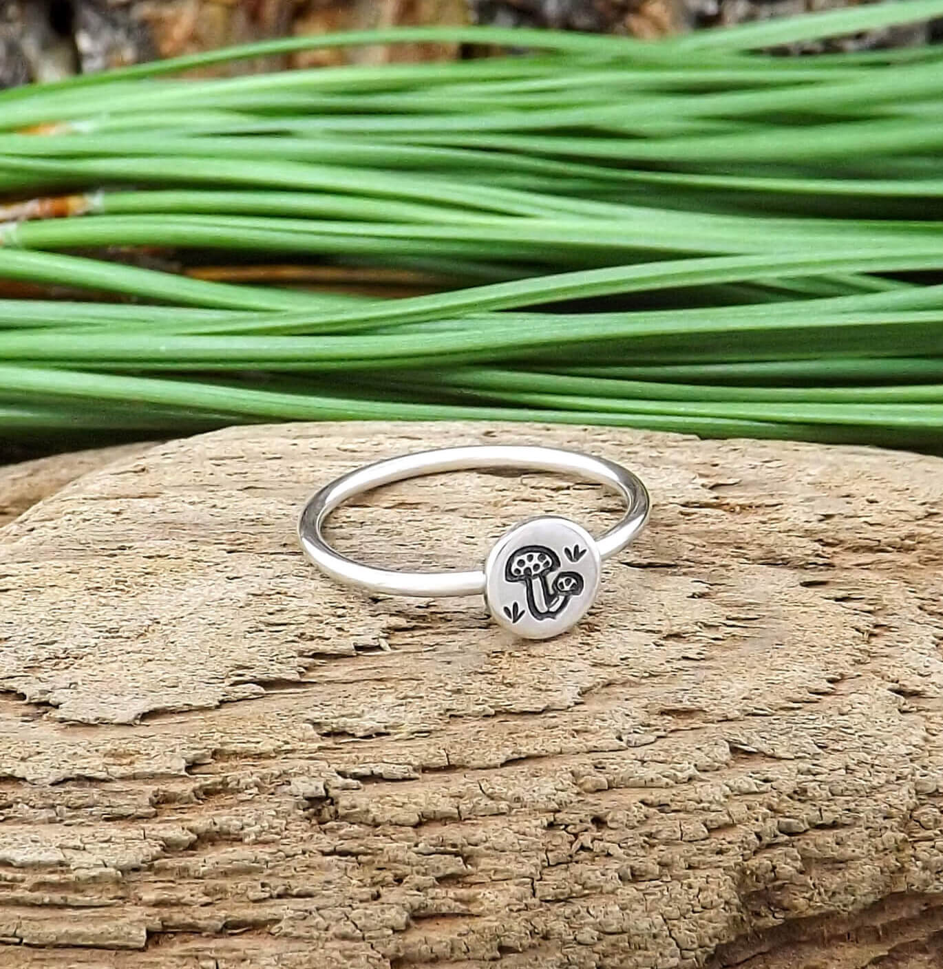 Left angle view of sterling silver stacking ring hand-stamped with mushroom design.