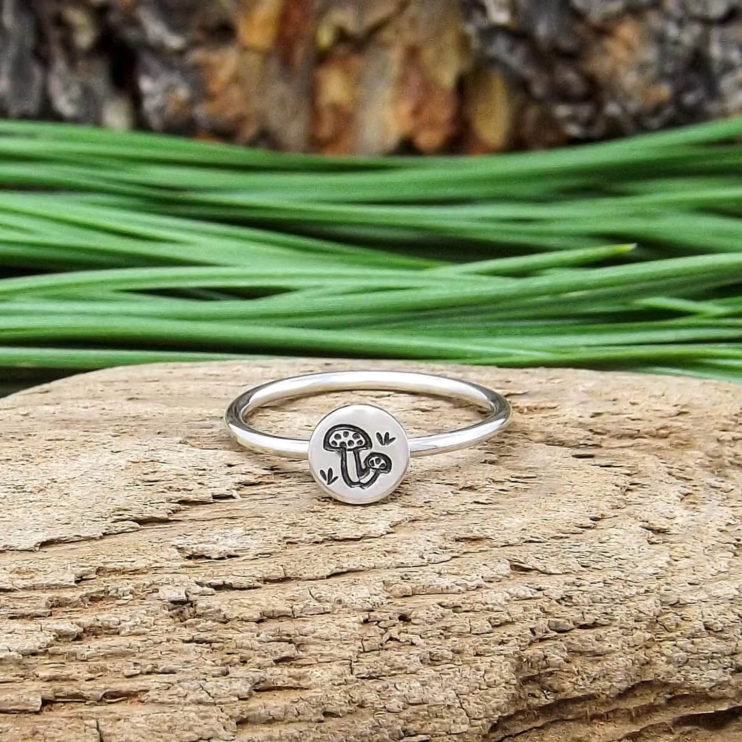 Front view of sterling silver stacking ring hand-stamped with mushroom design.