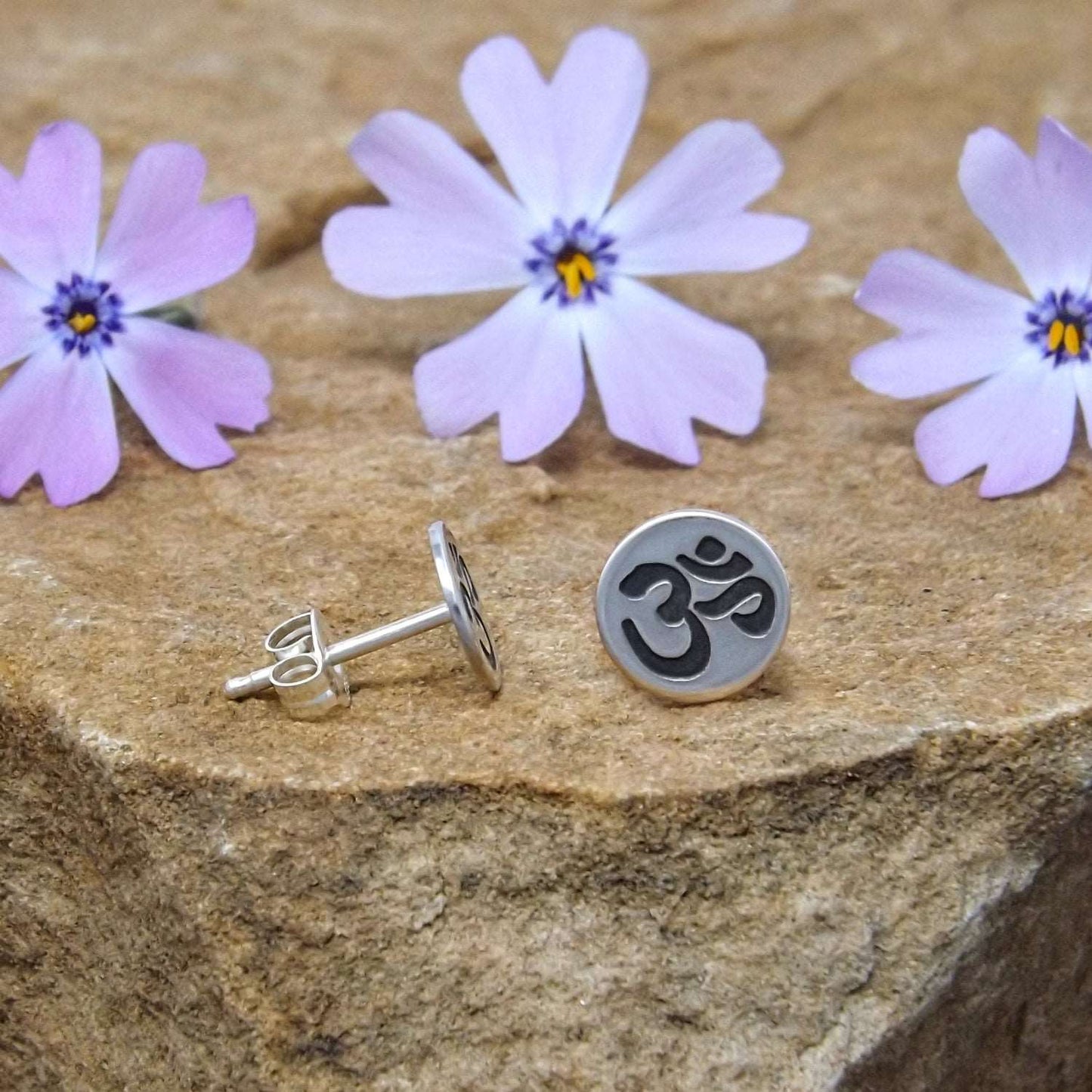 Size view of sterling silver stud earrings hand-stamped with om design.