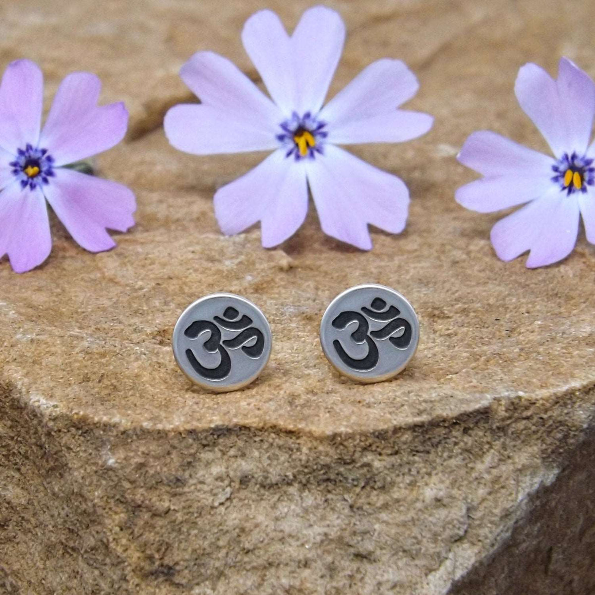 Front view of sterling silver stud earrings hand-stamped with om design.