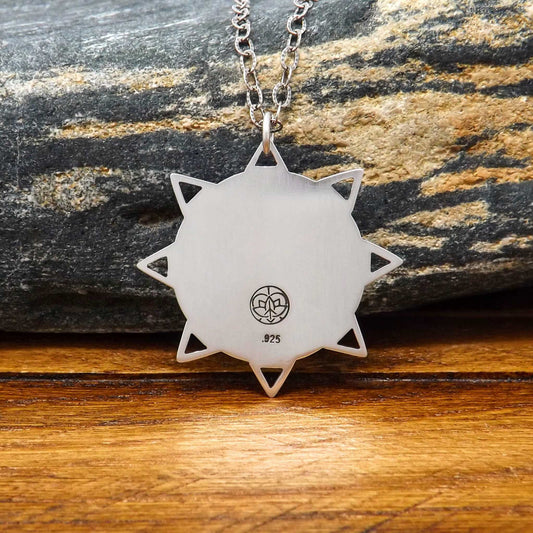 Back view of a sterling silver om sun necklace with a makers mark stamp.