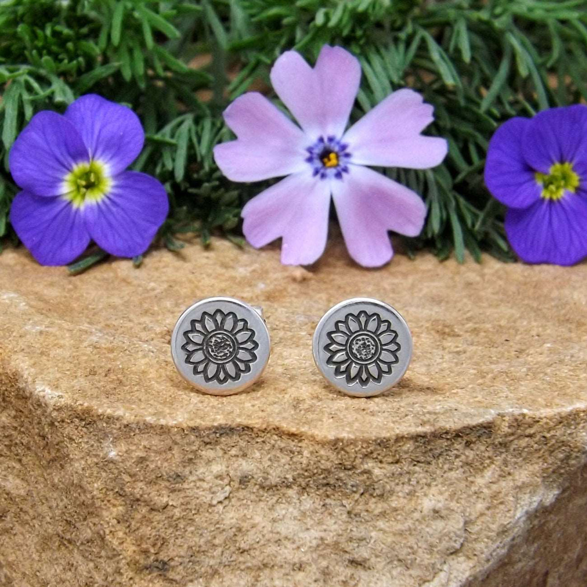Front view of sterling silver stud earrings hand-stamped with sunflower design.