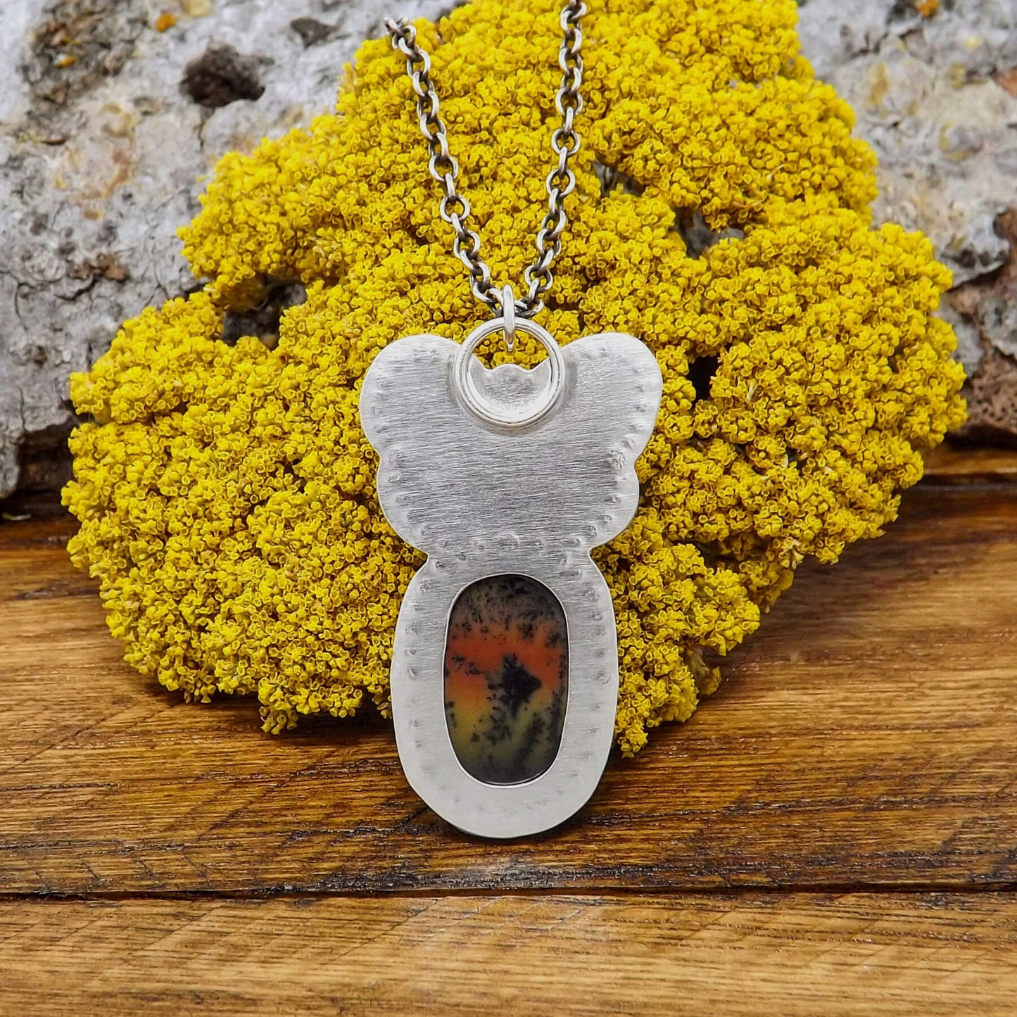 Back view of a sterling silver dendritic agate gemstone necklace with butterfly design and hand-stamped details.