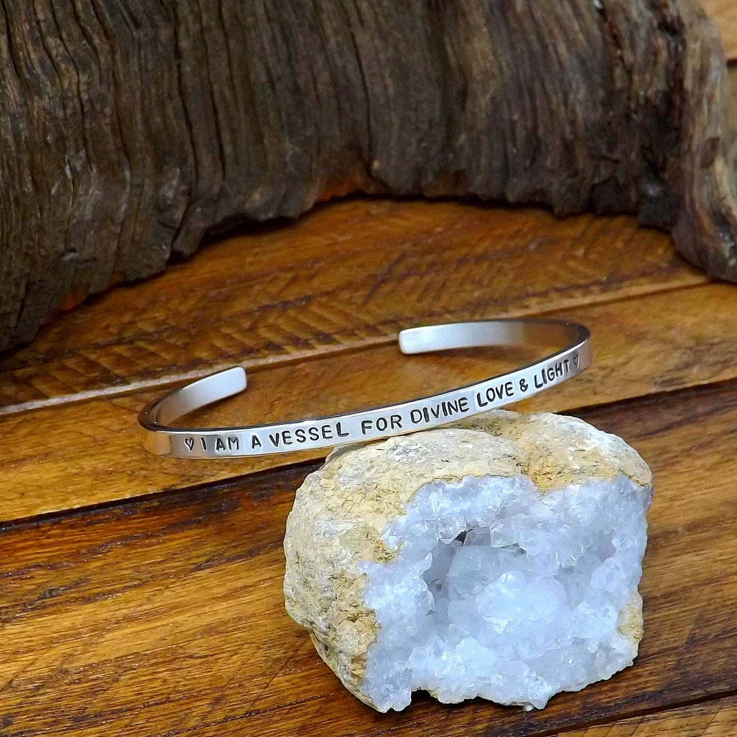 Left side view of a sterling silver affirmation cuff bracelet hand-stamped with "I AM A VESSEL FOR DIVINE LOVE & LIGHT".