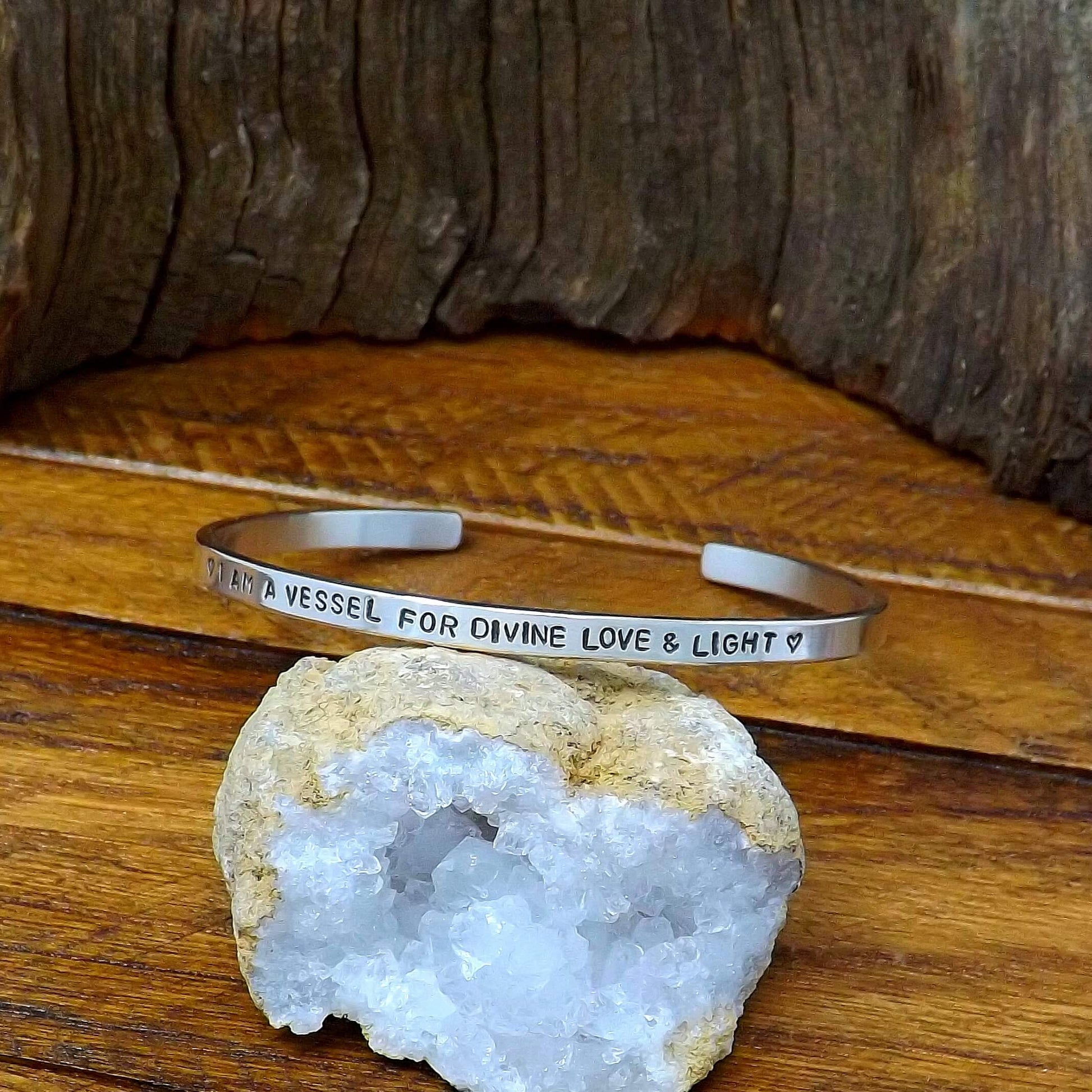 Right side view of a sterling silver affirmation cuff bracelet hand-stamped with "I AM A VESSEL FOR DIVINE LOVE & LIGHT".