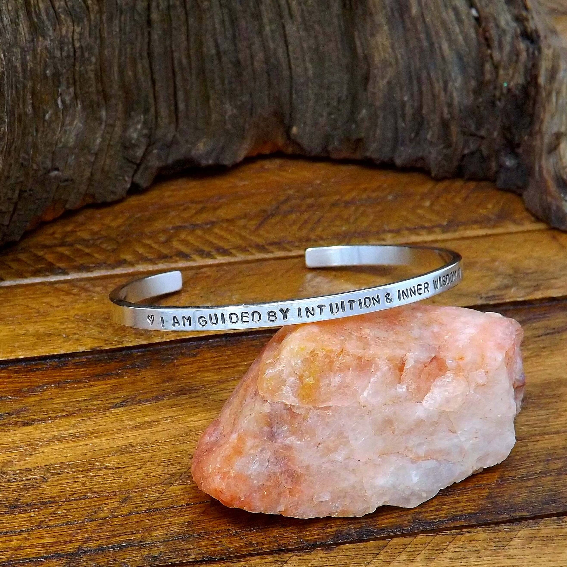 Left side view of a sterling silver affirmation cuff bracelet hand-stamped with "I Am Guided by Intuition & Inner Wisdom".