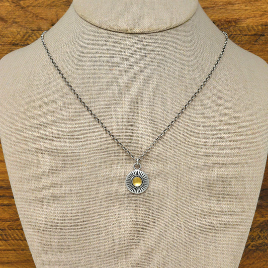 Bust view of a sterling silver sunburst necklace with a rose cut faceted citrine gemstone.