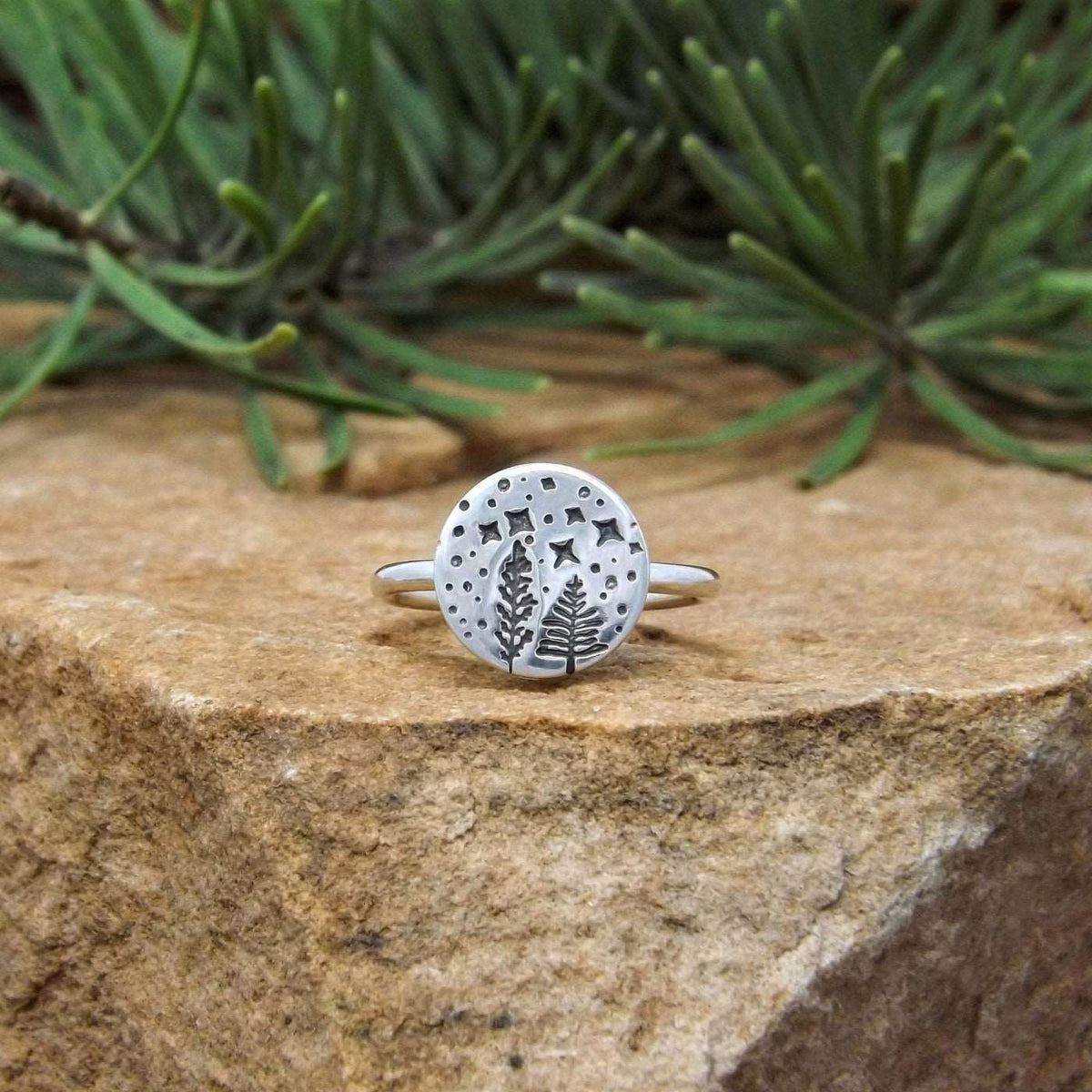 Front view of sterling silver ring hand-stamped with a starry night forest design.