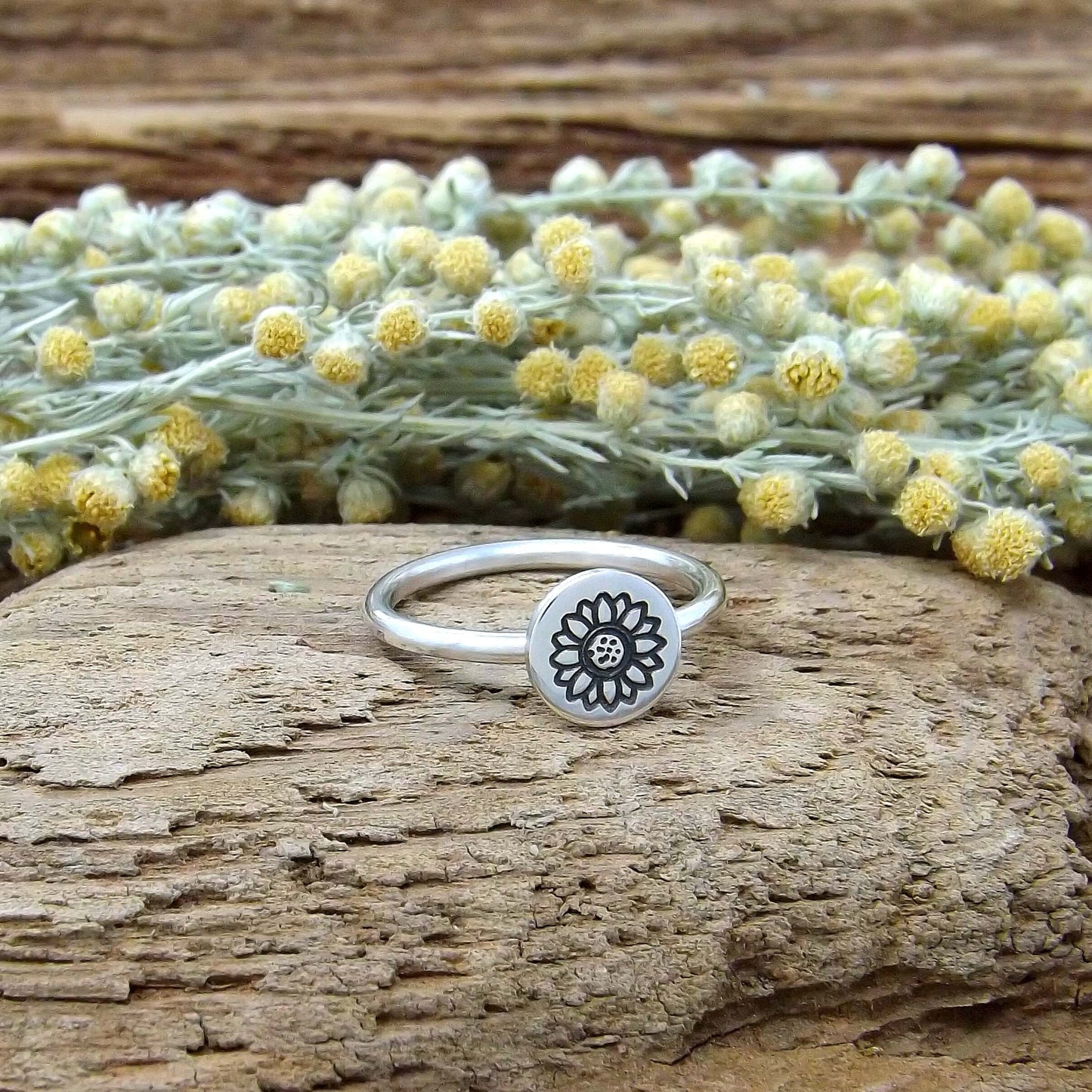 Left angle view of sterling silver stacking ring hand-stamped with sunflower design.