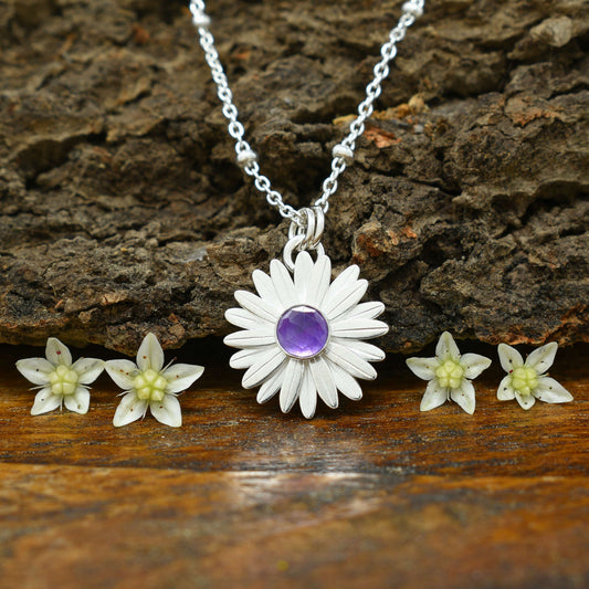 A sterling silver daisy necklace with a faceted amethyst at the flower center.