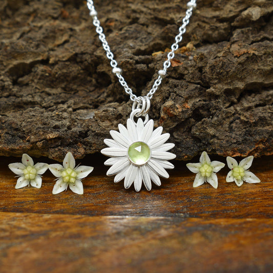 A sterling silver peridot necklace with a faceted amethyst at the flower center.