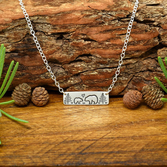 Hand-stamped sterling silver mama bear and baby bear bar necklace with trees and a small heart.